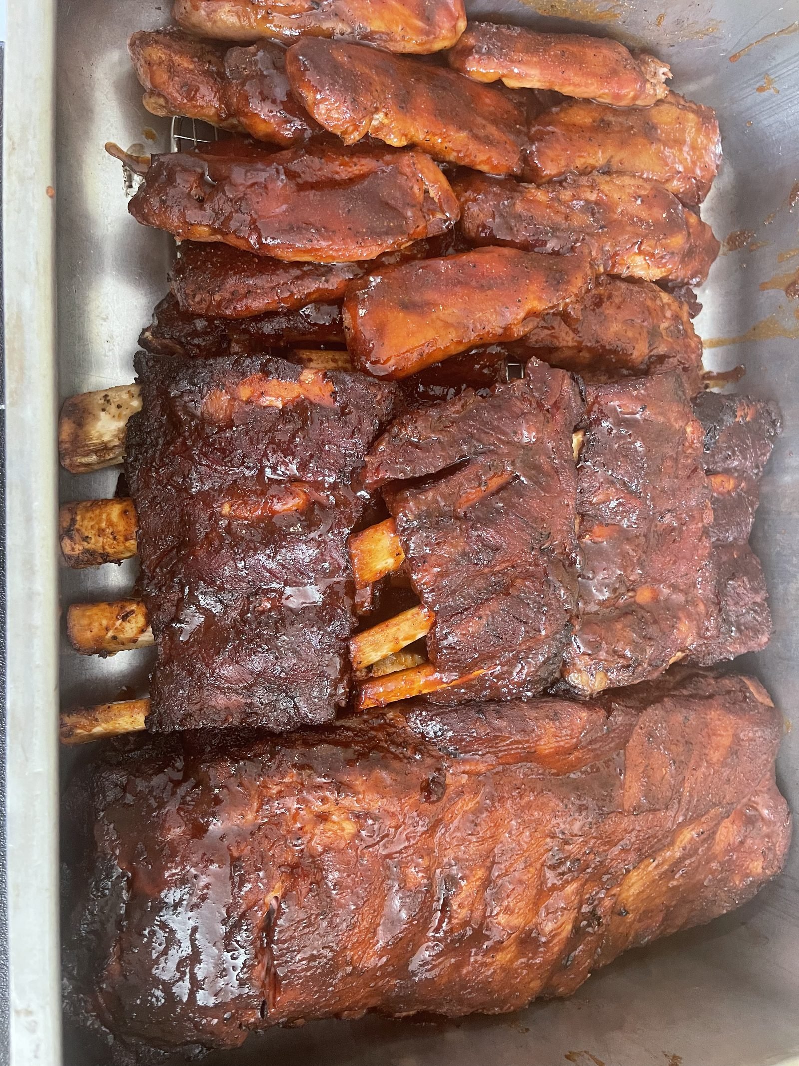 Pans of slow-smoked ribs