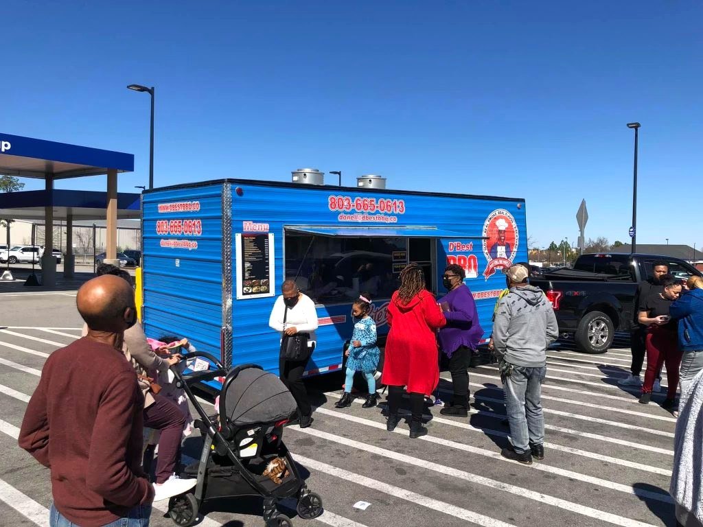 A line of customers at the D'Best BBQ truck window